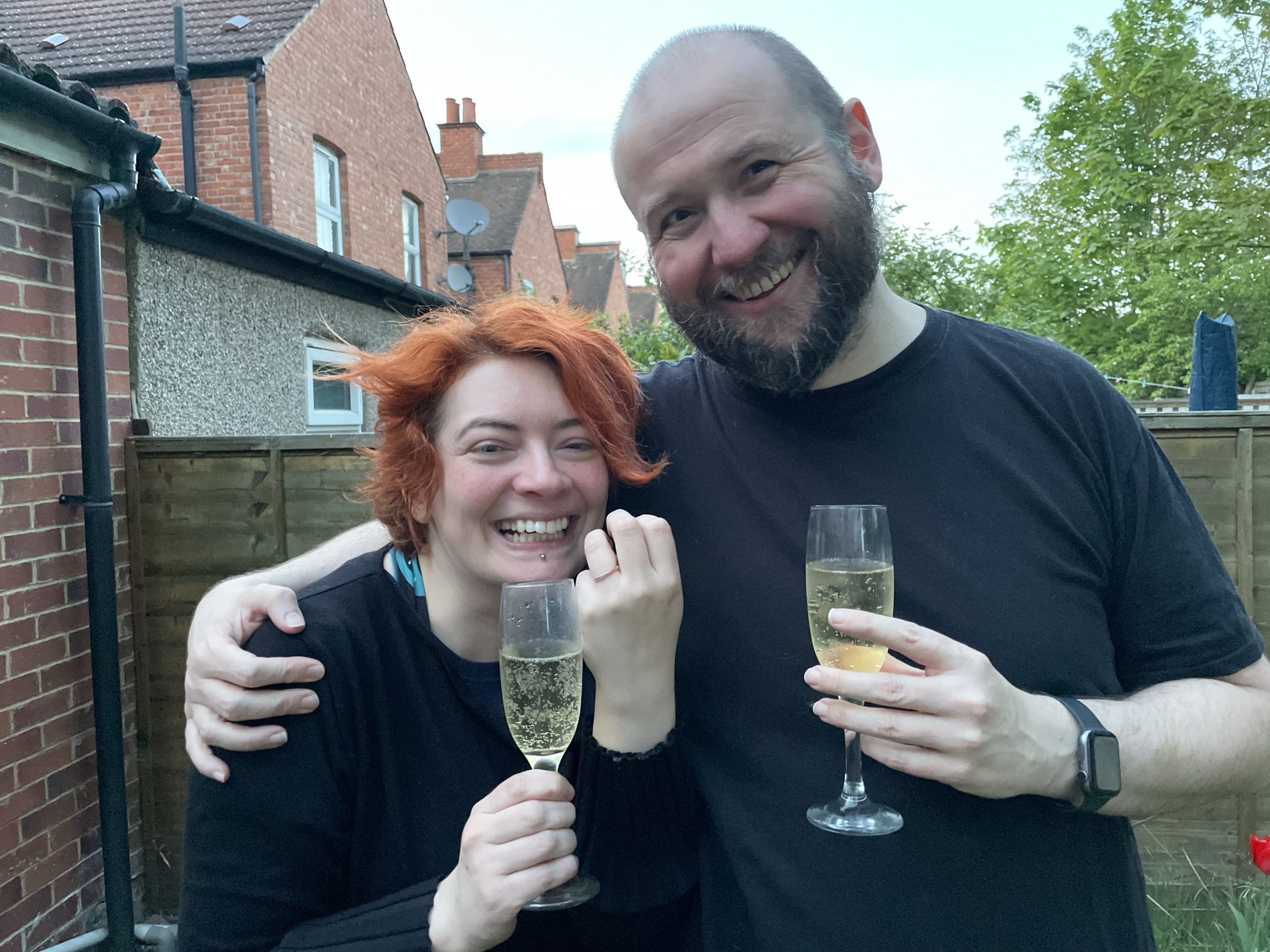 a photo of the two of us, holding champagne and showing off the engagement ring